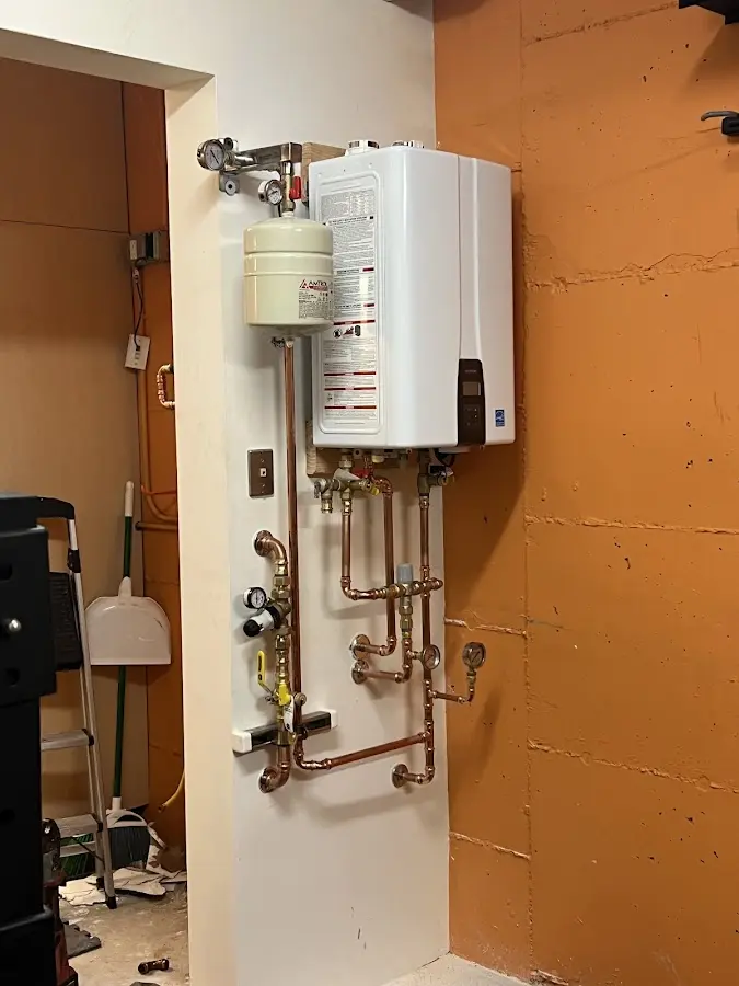Plumbing technician inspecting water heater connections in Altus